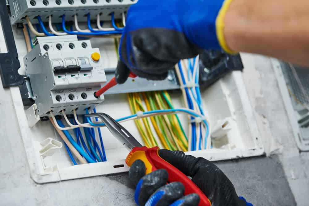 Precyzyjne podłączenie instalacji elektrycznej, elektryk w pracy.